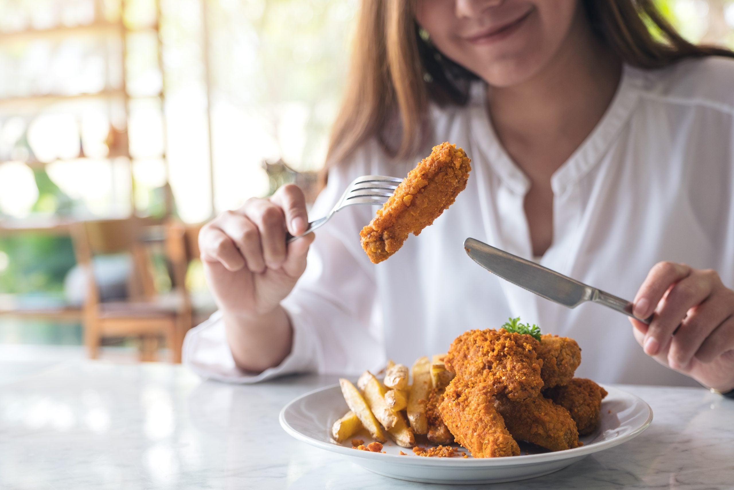 Woman easting breaded chicken